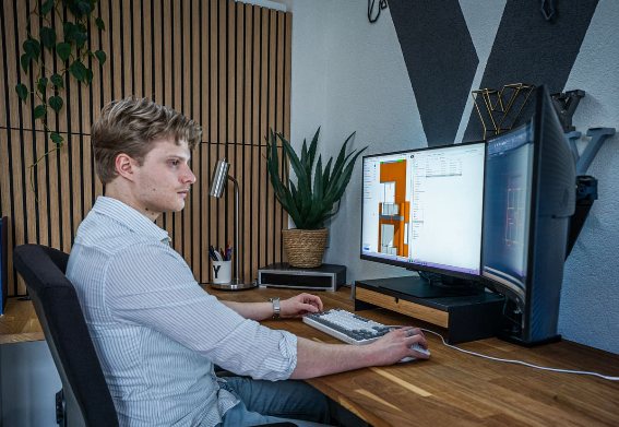 De werkplek van Tekenbureau Winter, met dubbel beeldscherm en bouwkundige tekeningen